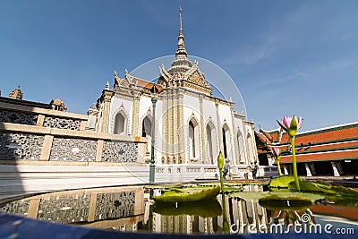Reflection of Phra Viharn Yod temple in a pond with lotus flower at Grand Palace complex in Bangkok, Thailand Stock Photo