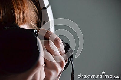 Reflection of a redhead girl in headphones and with a camera Stock Photo