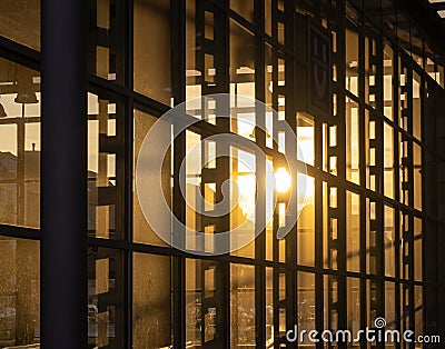 Reflection of the setting sun in the fully glazed facade of a hi Stock Photo