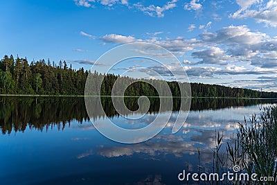 symmetry and Reflection of sky, clouds and trees in lake water Stock Photo