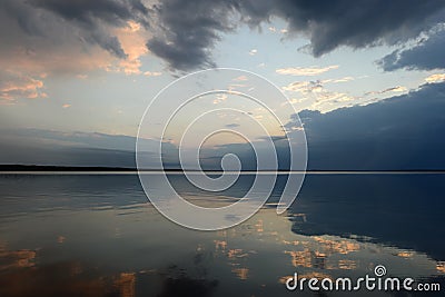 Reflection of the sky in the lake water in the calmness at sunset Stock Photo