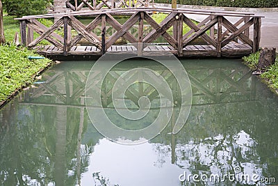 Reflection of the small wooden bridge in the mirror smooth Stock Photo
