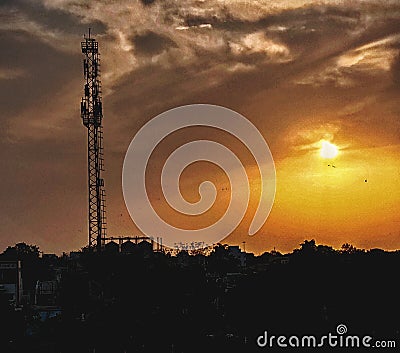 Reflection of sun rays are too good. There are many factories, towers, and trees also. Stock Photo