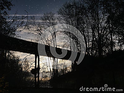 Reflection in the water, bridge and trees are reflected on the water surface. Stock Photo