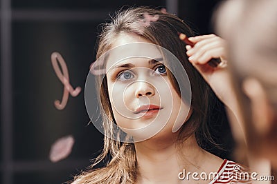 Reflection of young womanwriting affirmation words I love you to herself in mirror , concept human psychology and self treatment Stock Photo