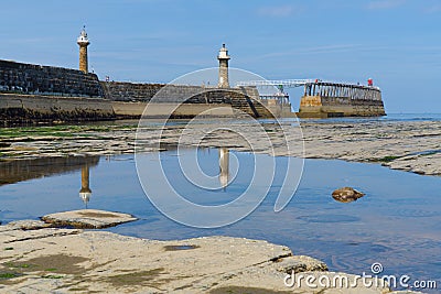 Reflections of East and West lighthouses in tidal pool. Whitby. North Yorkshire. Editorial Stock Photo