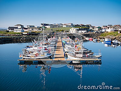 With reflections in the water, local fishing and leisure boats moored at Hamnavoe Marina in Shetland, Scotland, UK Editorial Stock Photo