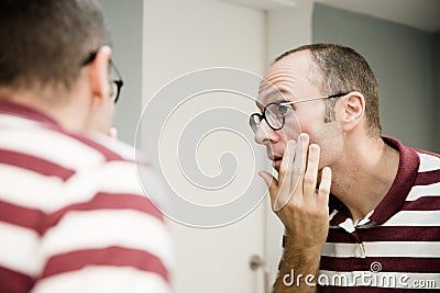 Reflective image of a man looking into a mirror Stock Photo