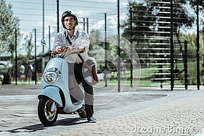 Reflective male student typing friends on motorbike Stock Photo