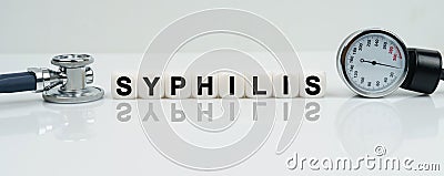 On a reflective white surface lies a stethoscope and cubes with the inscription - SYPHILIS Stock Photo