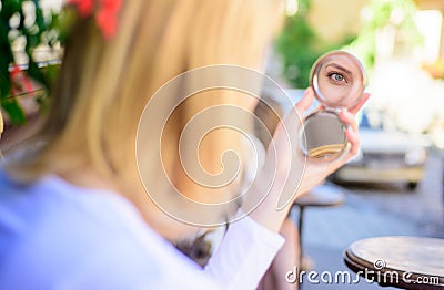 Reflexion girl looking in mirror check her appearance. Check if everything is right. Woman looking in her pocket mirror Stock Photo