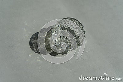 Refraction and reflection of light casts shade and shadow on white paper background. Sparkling glass crystals refract harsh Stock Photo