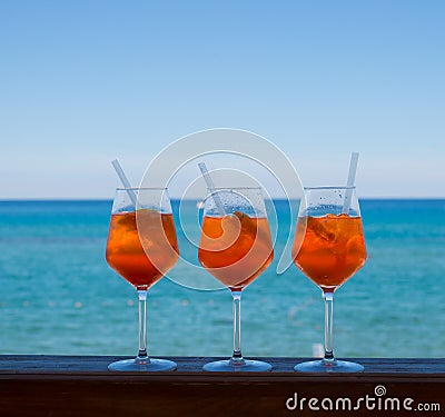 Refreshing aperitif Aperol spritz on a background of blue sea. Stock Photo