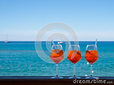 Refreshing aperitif Aperol spritz on a background of blue sea an Stock Photo