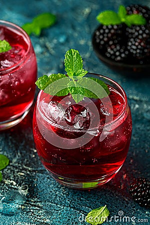 Refreshing Blackberry cocktail with ice and mint on rustic background Stock Photo