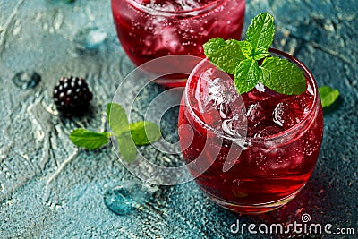 Refreshing Blackberry cocktail with ice and mint on rustic background Stock Photo