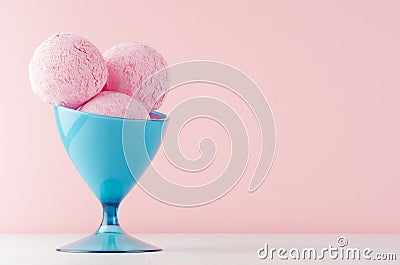 Refreshing classic pink creamy ice cream balls in elegant blue bowl on white wooden table and soft light pastel pink background Stock Photo