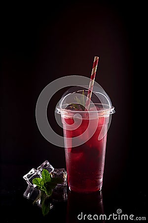 Refreshing cool lemonade with strawberries, mint and ice in plastic glass Stock Photo