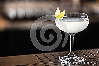 Refreshing French cocktail 75 decorated with lemon peel in a glass at the bar Stock Photo