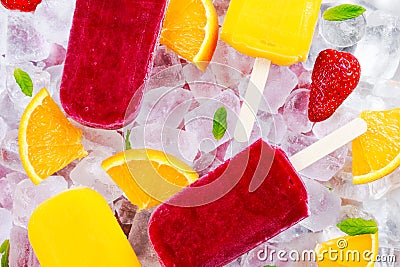 Refreshing fruit popsicle lollies on ice background with berries, peppermint. Stock Photo