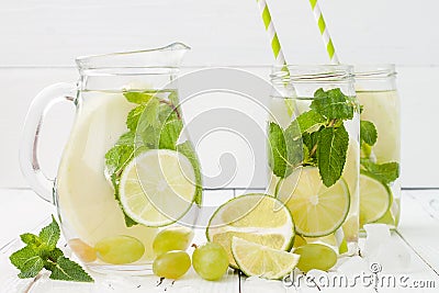 Refreshing homemade lime and mint cocktail over old vintage wooden table. Detox fruit infused flavored water. Clean eating Stock Photo