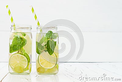 Refreshing homemade lime and mint cocktail over old vintage wooden table. Detox fruit infused flavored water. Clean eating Stock Photo