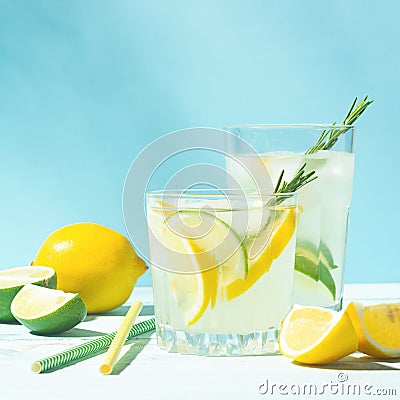 A refreshing lemon lime drink with ice cubes in glass goblets against a blue background. Summer cocktail. Copy space. Stock Photo