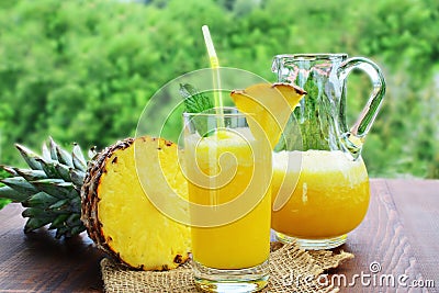 Refreshing pineapple mocktail drink in glass and pitcher Stock Photo