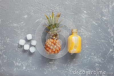 Refreshing yellow smoothie with pineapple and ice cubes on gray wooden table, top view Stock Photo