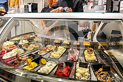 Refrigerated display case with a large assortment of soft ice cream in an Italian store Editorial Stock Photo