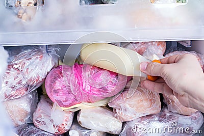 Refrigerator with frozen food. Frozen milk. Open fridge freezer meat, milk, vegetables. Stock Photo