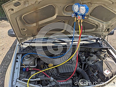 Refueling a car air conditioner with freon Editorial Stock Photo