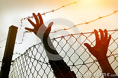 Refugee men and fence Stock Photo