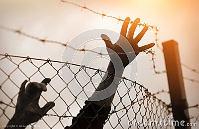 Refugee men and fence Stock Photo