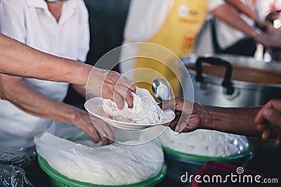 Refugees' hands are receiving food from philanthropists: the concept of hunger problems for the poor Stock Photo