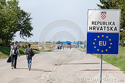 Refugees passing in front of the EU entrance sign in front of the Serbia-Croatia border crossing of Sid Tovarnik Editorial Stock Photo