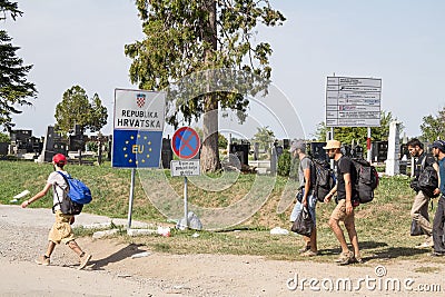 Refugees passing in front of the EU entrance sign in front of the Serbia-Croatia border crossing of Sid Tovarnik on Balkans Route Editorial Stock Photo