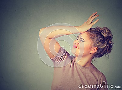 Regrets wrong doing. Silly woman, slapping hand on head having duh moment Stock Photo