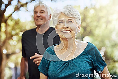 Regular exercise is great for boosting your wellness. a senior couple out for a run together. Stock Photo