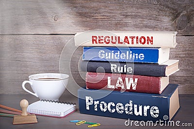 Regulation concept. Stack of books on wooden desk Stock Photo