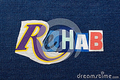 REHAB text word collage, colorful fabric on blue denim, rehabilitation and recovery Stock Photo