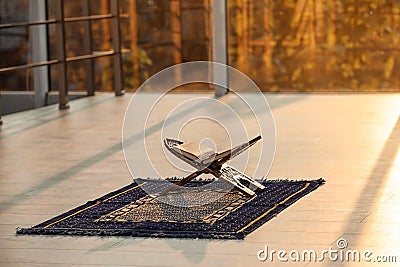 Rehal with open Quran on Muslim prayer mat Stock Photo