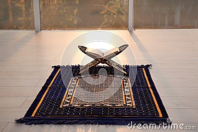 Rehal with open Quran on Muslim prayer rug Stock Photo