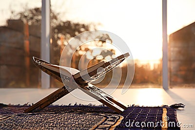 Rehal with open Quran on Muslim prayer rug Stock Photo
