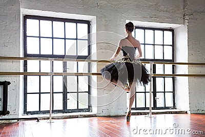 Rehearsal ballerina in the hall. Wooden floor, very large windows. Beautiful ballerina in the rehearsal room Stock Photo