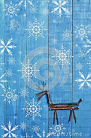 Reindeer made from dry sticks on wooden, blue background. Snow flaks image, ornament, craft Stock Photo