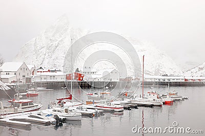 Reine fishing village on Lofoten islands with red rorbu houses in winter with snow. Lofoten islands, Norway, Europe Stock Photo