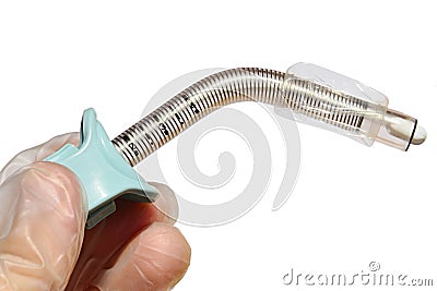 Reinforced fenestrated tracheostomy tube with deflated cuff held in left hand of doctor in latex glove, white background Stock Photo