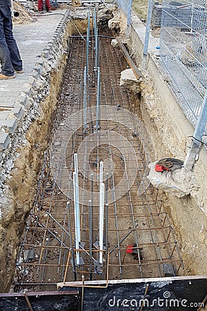 Reinforcement of a concrete basis. The location of the foundation of the new building, parts and fittings made of steel rods and Stock Photo