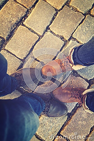 Relationship in a pair of lovers, two side by side. feet in shoes on the paving slabs. Stock Photo